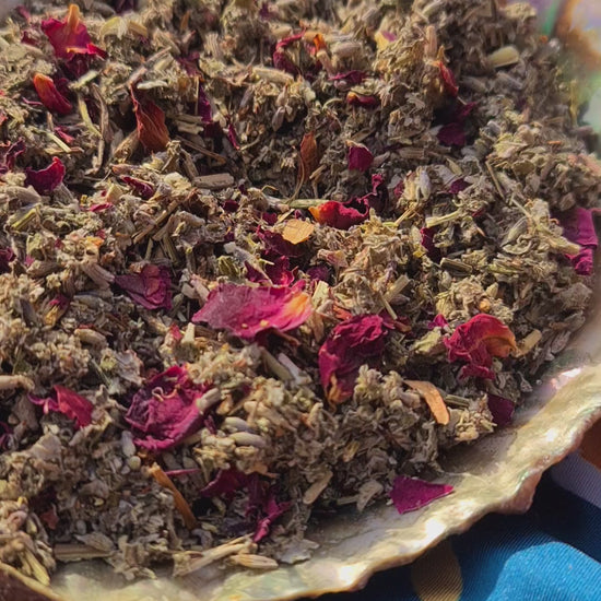 A captivating video of The Dreamy Blend in an iridescent abalone shell, featuring a mixture of green raspberry leaf and mugwort, beautifully accented with specks of rose petals and lavender. Liam is sprinkling the blend into the Abalone Shell.