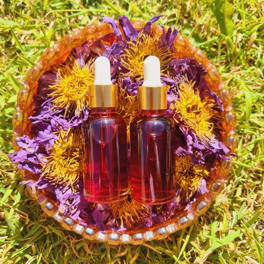 A vibrant image featuring a Blue Lotus tincture elixir placed atop a bed of blue lotus petals, nestled in an eye-catching orange glass bowl, set against the lush green grass, evoking a sense of natural vitality and wellness.